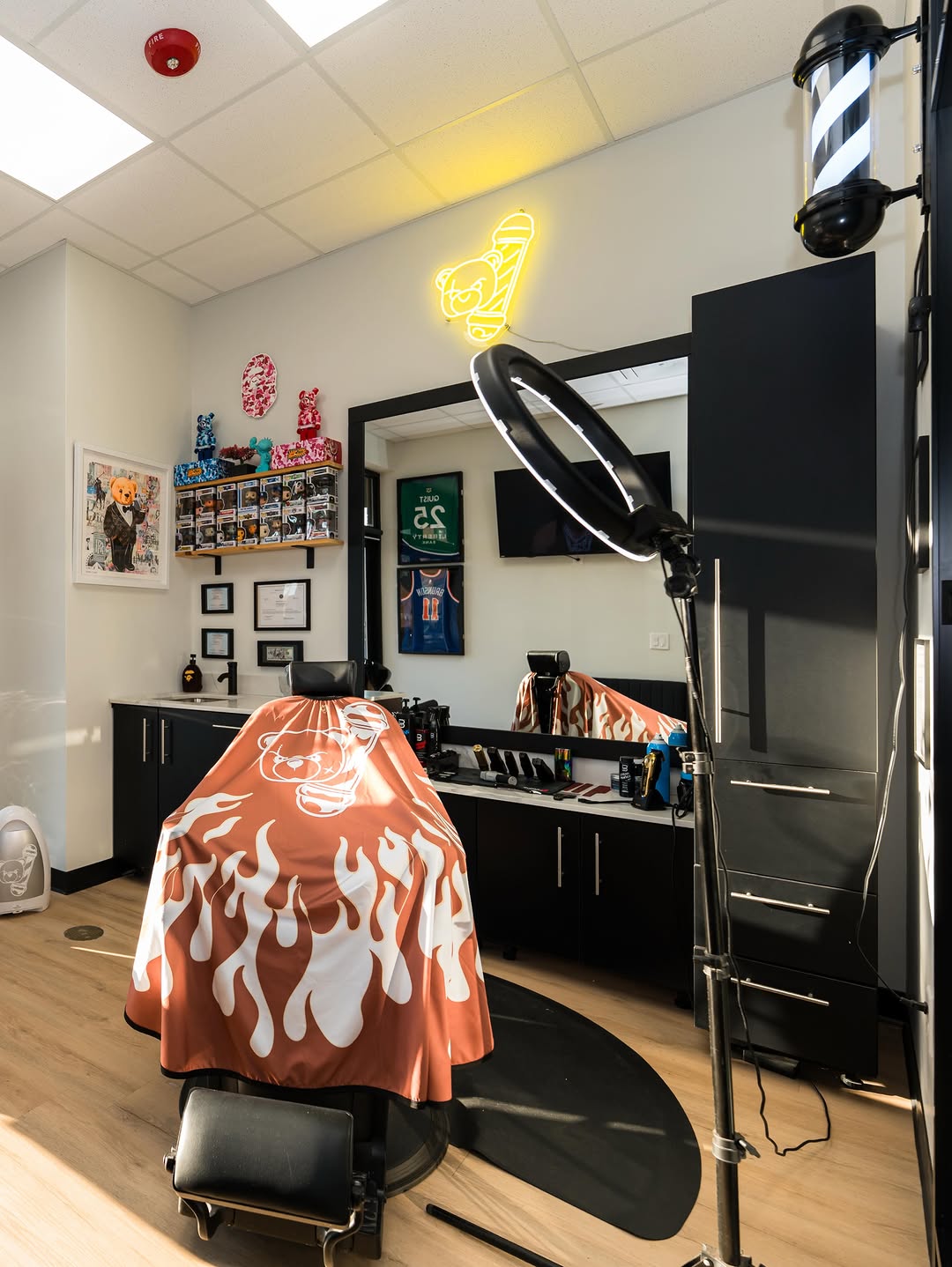 The chair at Tedi's Hair Studio, draped in the green cape with the bear mark